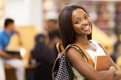 African American female student smiling with notebook and backpack