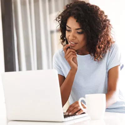 African American woman looking something up on her laptop