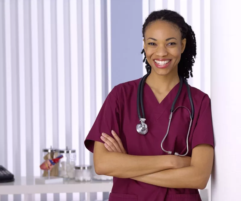 A young African American black female doctor smiles at a hospital