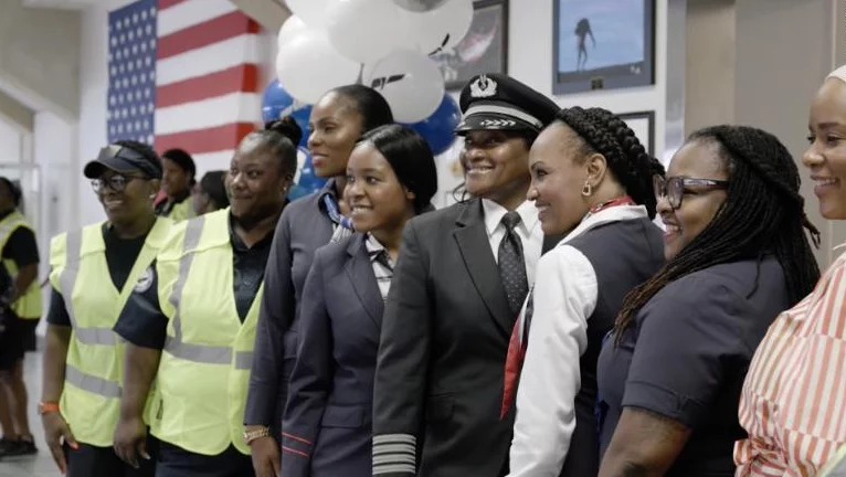 African American black men and women who work for the airline line up and smile