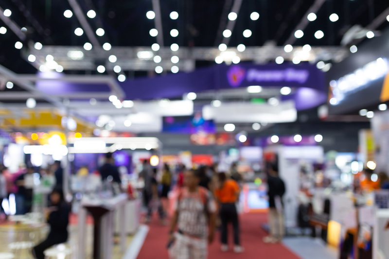 Abstract blur people in exhibition hall event trade show expo background. Business convention show, job fair, or stock market. Organization or company event, commercial trading, or shopping mall marketing advertisement concept.
