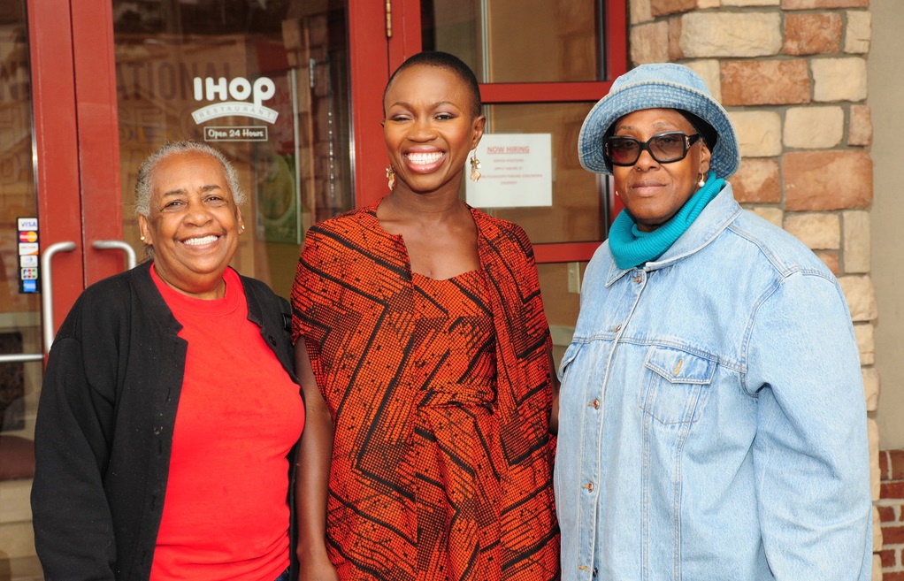 Adenah Bayo pictured in the middle with two other women in front of a IHOP.