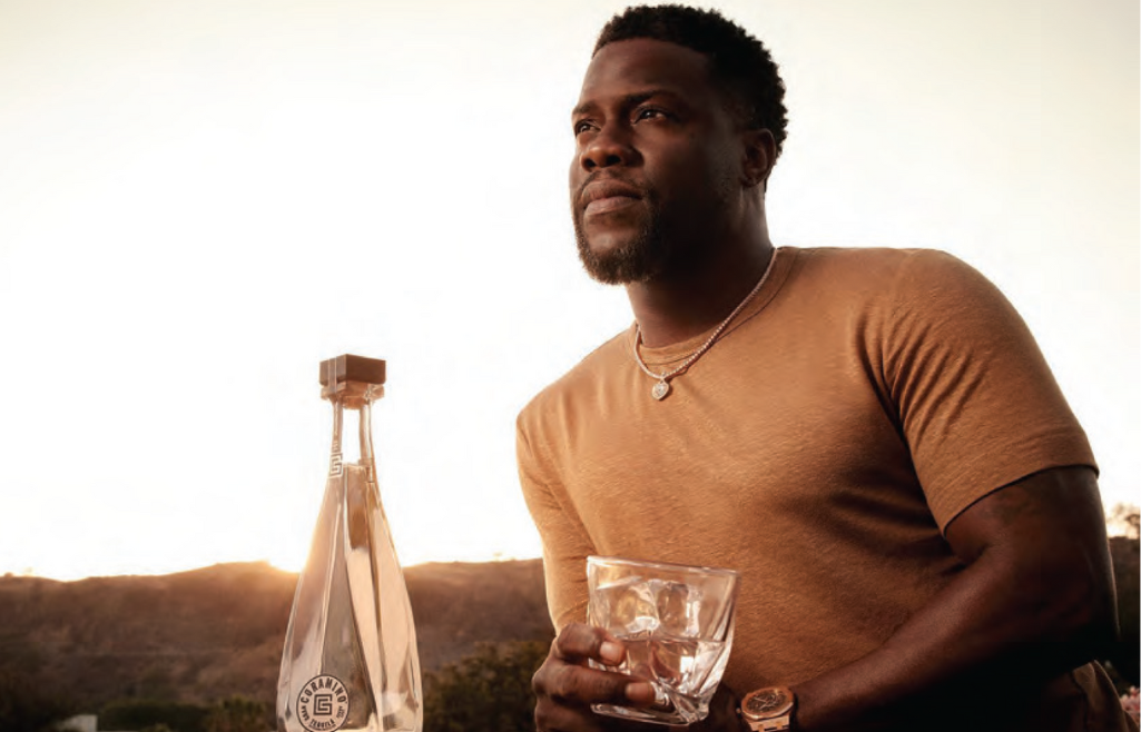 Kevin Hart with glass of Coramino Tequilla in hand looking stoic