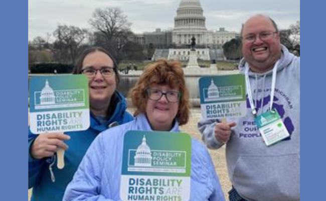 disability seminar attendees holding disability rights signs smiling